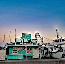 boats are parked at the dock in front of a small shop with a sign that says don't baut shop