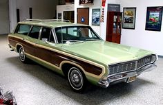 an old station wagon is parked in a garage with other cars and memorabilia on the walls