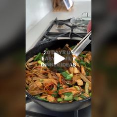 a wok filled with stir fry vegetables on top of a stove