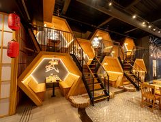 the interior of a restaurant with wooden walls and stairs leading up to an upper level