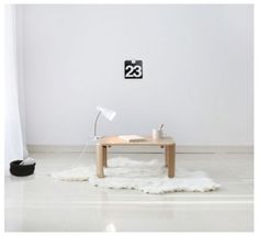 a white room with a wooden table and black numbers on the wall, along with a rug