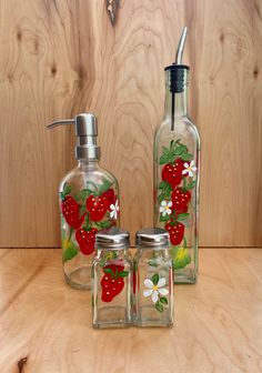 three glass jars with strawberries painted on them