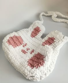 a crocheted purse with pink hearts on it