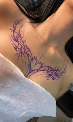 a woman with purple ink on her chest