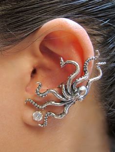 an ear is adorned with silver jewelry