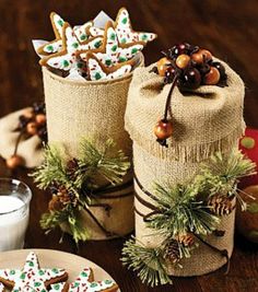 christmas cookies and other holiday treats are on the table next to two jars filled with decorations