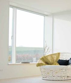 a white basket sitting on top of a wooden floor in front of a large window