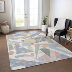 a living room area with a rug, chair and potted plant on the floor