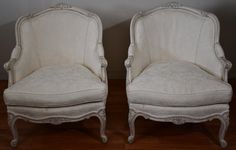 two white chairs sitting next to each other on top of a wooden floor