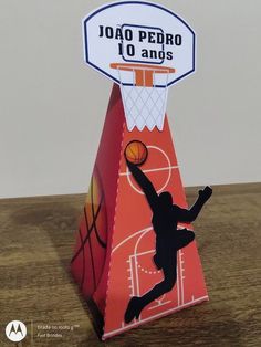 an origami basketball trophy with a player jumping up to dunk the ball