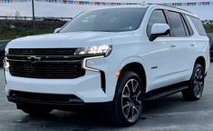 a white chevrolet suv parked in a parking lot