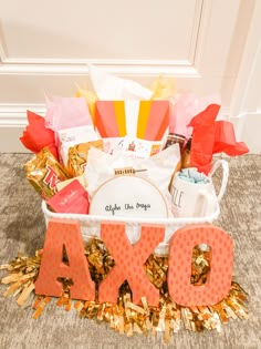 a basket filled with lots of different types of items on the floor next to a sign that says aoxo