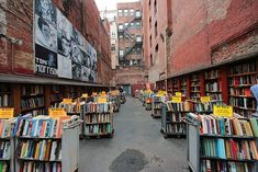 an alleyway filled with lots of books and people looking at them in the distance