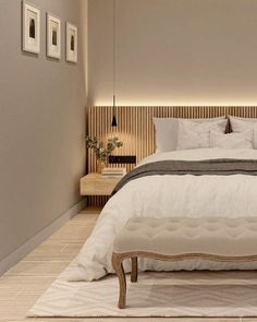 a bedroom with a bed, nightstands and pictures on the wall above it in neutral colors