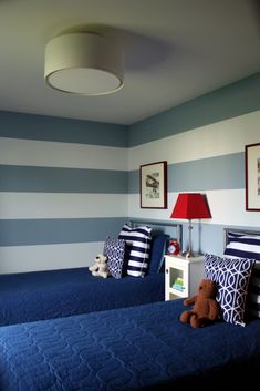 two twin beds in a bedroom with blue and white striped walls