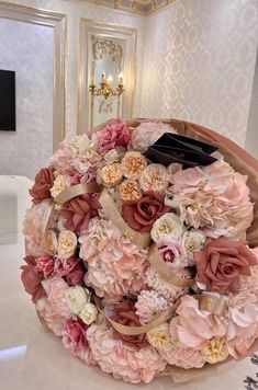 a bouquet of pink and white flowers sitting on top of a table in a room