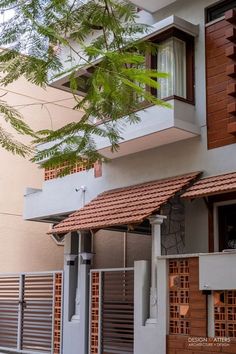 an apartment building with wooden slats on the front and side walls, next to a tree