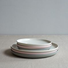 three plates stacked on top of each other in front of a gray wall and floor