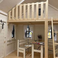 there is a loft bed in the middle of this room with a desk underneath it