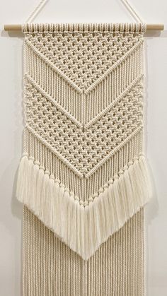 a white wall hanging with tassels on it