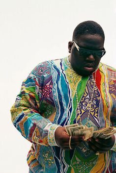 a man in colorful shirt and sunglasses looking at his cell phone