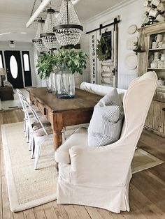 a dining room table with chairs and a chandelier hanging from it's ceiling