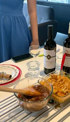 two bottles of wine and some food on a table