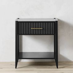 a black and gold side table against a white wall