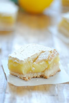 a piece of cake sitting on top of a table next to some lemons in the background