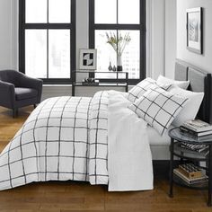 a bed with white and black comforters in a room