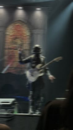 a blurry photo of a man playing guitar on stage