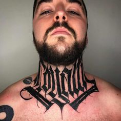 a man with tattoos on his neck and chest is looking up at the camera while wearing a black choker