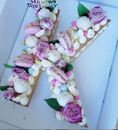 the letter k is decorated with flowers and marshmallows