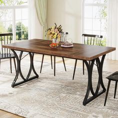 a dining room table with two chairs and a rug on the floor in front of it