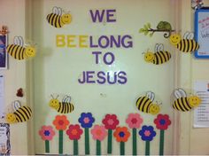 a door decorated with paper flowers and bees that says we belong to jesus on it