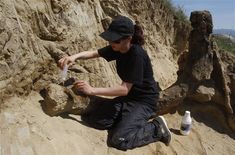 a man sitting on the side of a cliff next to a bottle and some rocks