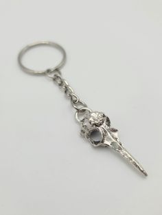 a metal key chain with a skull on it's end and an eyeball in the middle