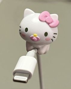 an image of a hello kitty plugged in to a charger with a pink bow on it