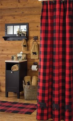 a red and black plaid shower curtain in a bathroom with wood paneling on the walls