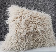 a white pillow with shaggy fur on it