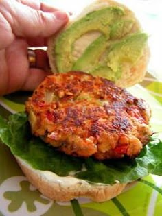 a person is holding an avocado on a burger