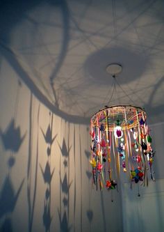 a chandelier hanging from the ceiling in a room with shadows on the wall