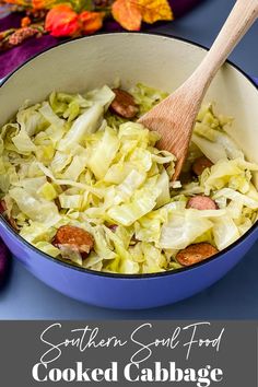 cooked cabbage and sausage in a blue pot with a wooden spoon on the side next to it