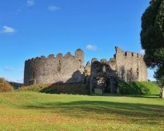 an old castle sitting on top of a lush green field