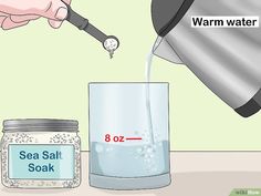 a person pouring sea salt into a glass with a measuring cup on the table next to it