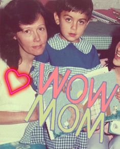 two women and a boy holding up a sign that says wow mom with hearts on it