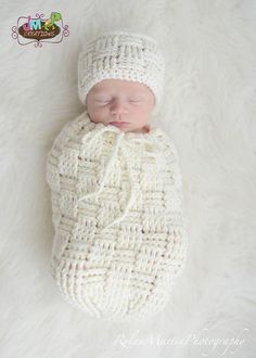 a newborn baby wearing a white knitted blanket and hat sleeping on a fur rug