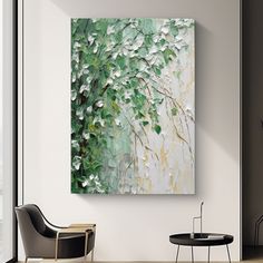 the painting is hanging on the wall near a chair and table in front of a window