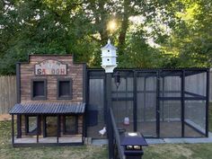 an old fashioned chicken coop in the back yard with a clock on it's side