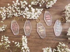 four clear acrylic keychains with the words dog mom printed on them